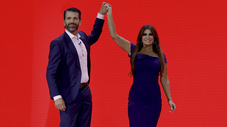 Donald Trump Jr. and Kimberly Guilfoyle posing together on-stage in 2023.