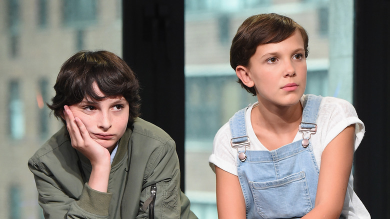 Finn Wolfhard looking glum beside Millie Bobby Brown