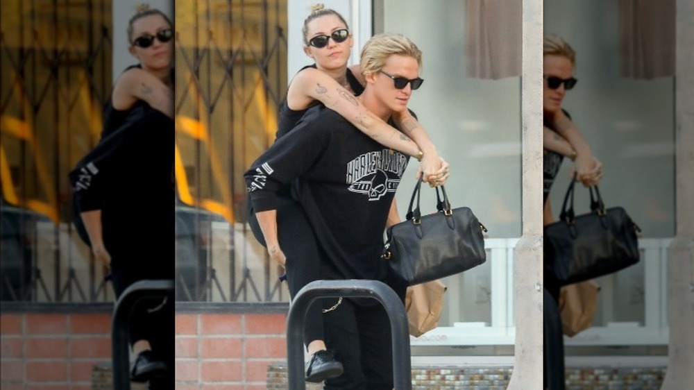 Miley Cyrus riding piggyback on boyfriend Cody Simpson