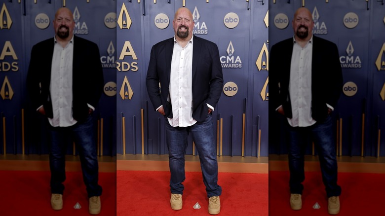 Paul Wight smiling in jeans at the 2024 CMA Awards