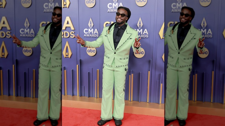 Shaboozey posing in a green suit at the 2024 CMA Awards