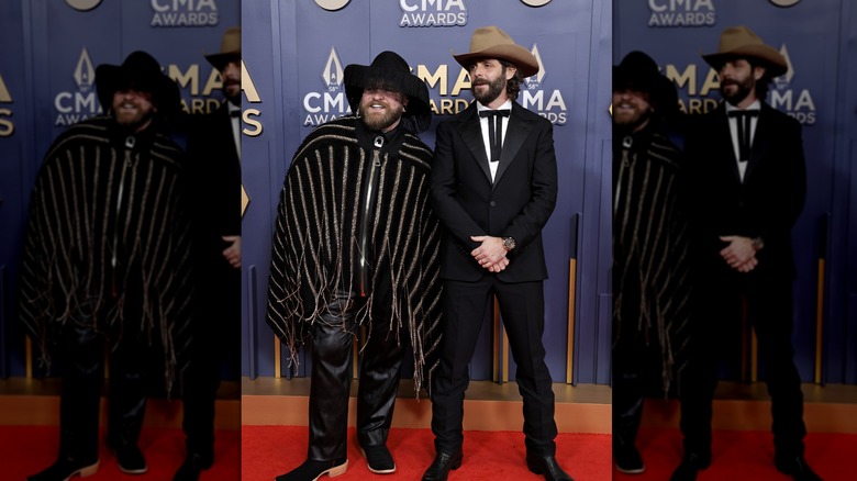 Teddy Swims and Thomas Rhett posing in black outfits at the 2024 CMA Awards