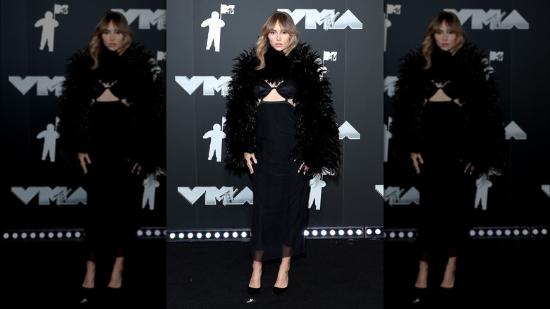 Suki Waterhouse wearing black feather bolero