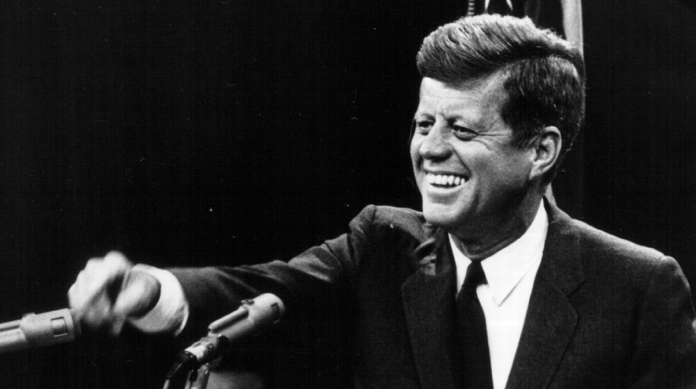 John F. Kennedy laughing at podium