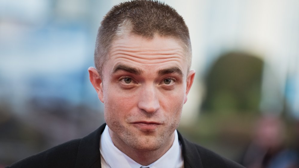 Robert Pattinson with a shaved head and light patch in his hair 