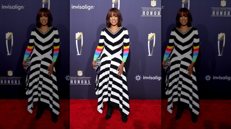 Gayle King posing at the NFL Honors in a striped dress