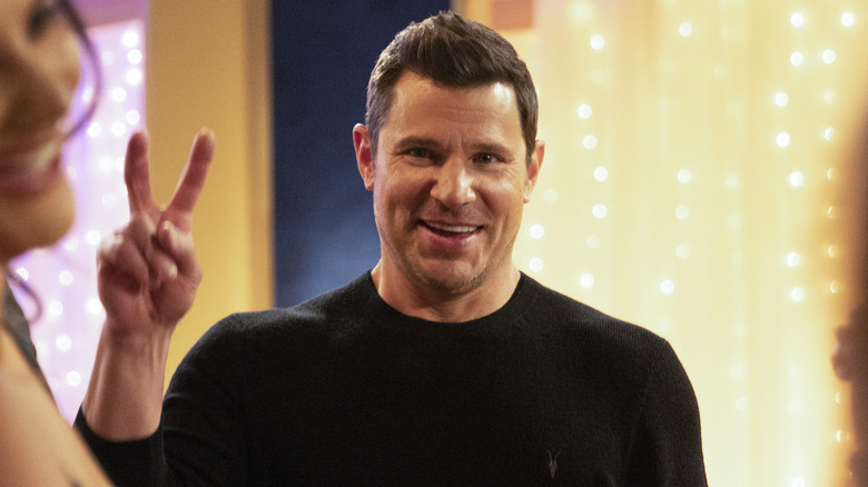 Nick Lachey smiling while making a peace sign