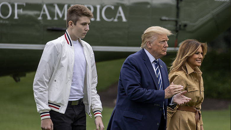 Barron Trump towering over his parents