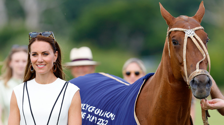 Kate Middleton posing next to a horse