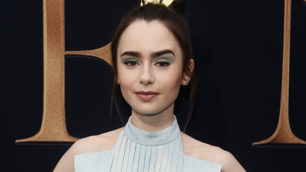 Lily Collins with a slight smile and arched eyebrow 