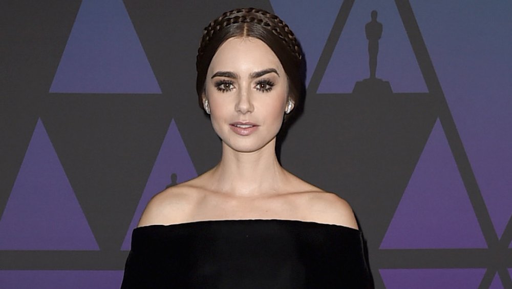 Lily Collins with a slight smile and arched eyebrow 