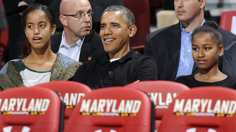 Malia, Barack, and Sasha Obama at a basketball game