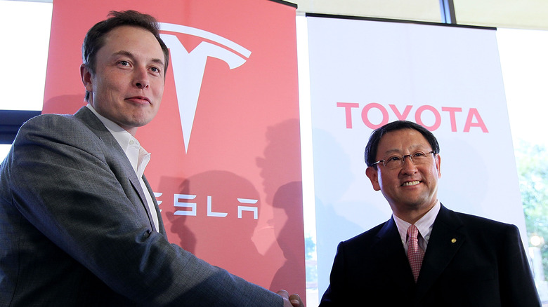 Elon Musk shakes hands with Toyota CEO