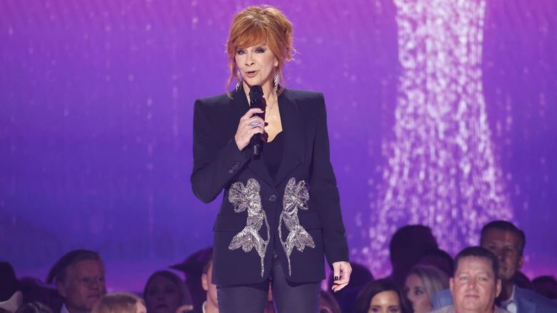 Reba McEntire performing in a purple outfit