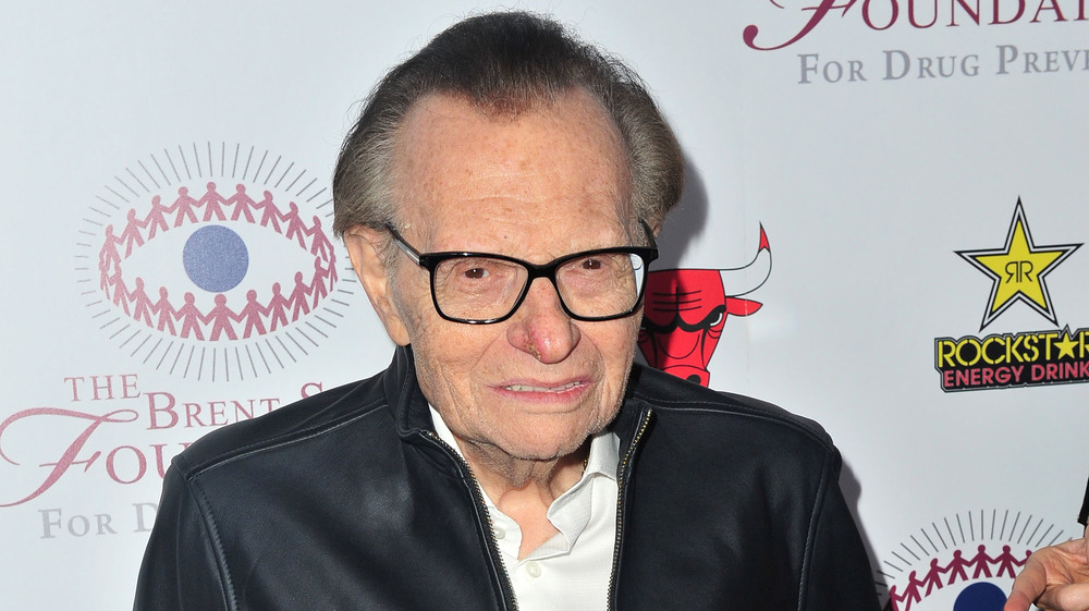 Larry King grimacing at the camera on the red carpet