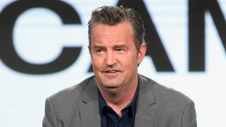 Matthew Perry in gray coat