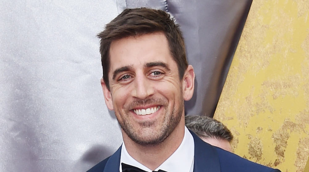 Aaron Rodgers smiles on the red carpet at the Oscars