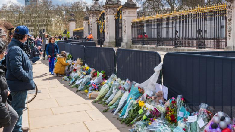 Bouquets of flowers are placed in front of Buckingham Palace