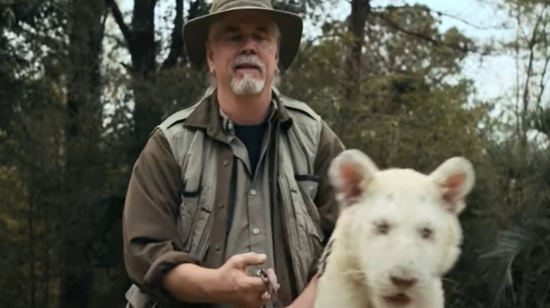 Doc Antle green hat holding white big cat