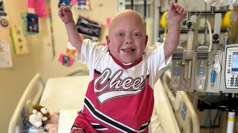 Bella Brave standing and smiling in a hospital bed