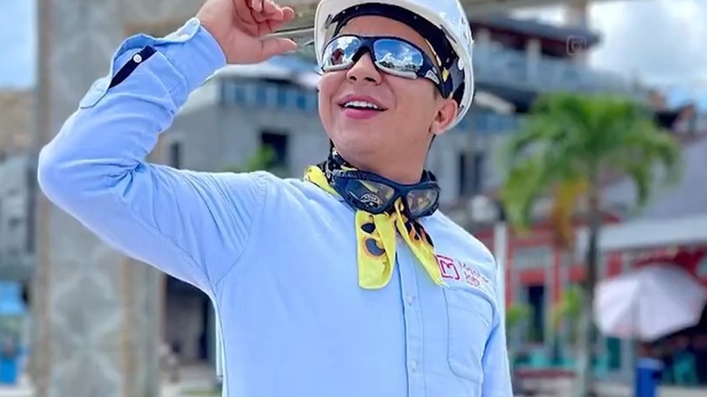 Jainer Moises Pinedo Vargas smiling while wearing a hard hat and sunglasses as he looks toward the sky