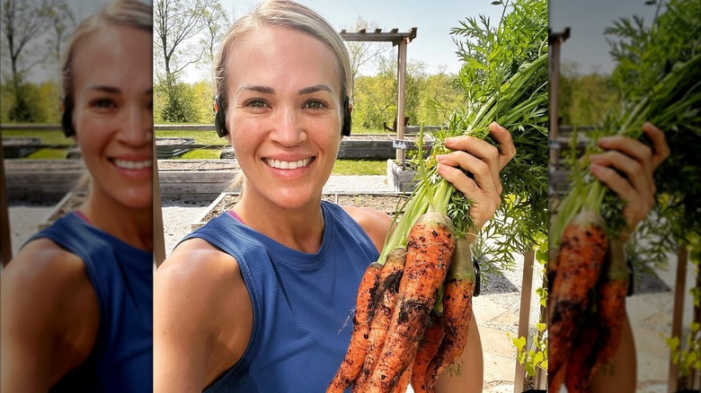 Carrie Underwood holding up a bunch of carrots