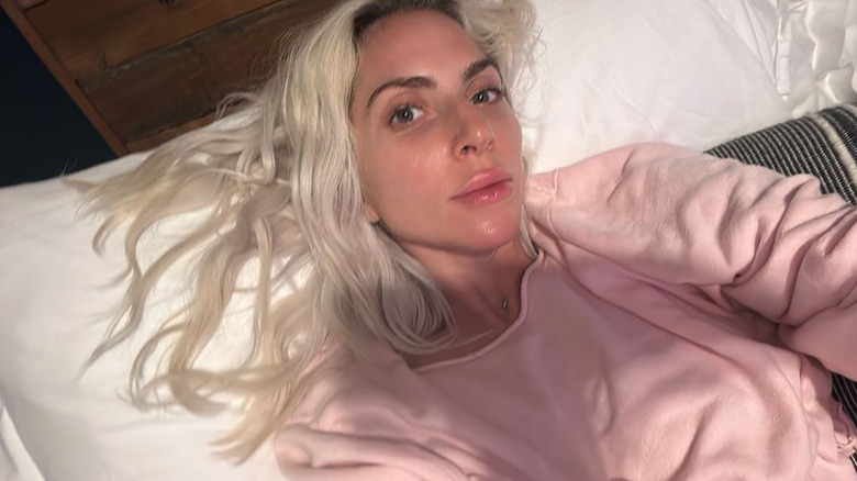 Lady Gaga in bed in a pink sweatshirt