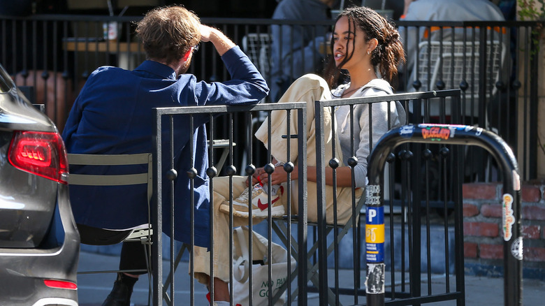 Malia Obama sitting with foot up in chair