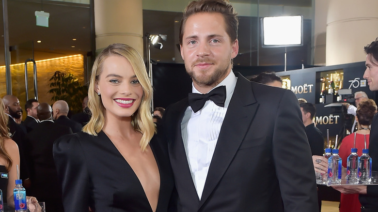 Margot Robbie and Tom Ackerley posing at event