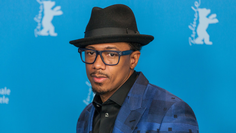 Nick Cannon wearing hat and glasses
