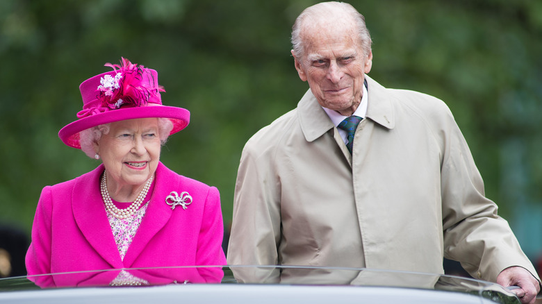 Prince Philip and the Queen riding a car.