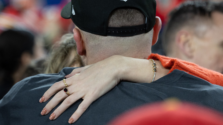 Taylor Swifts arm around Travis Kelce