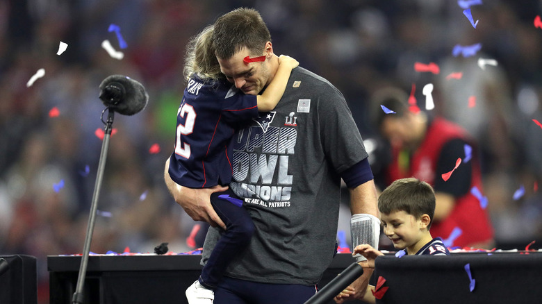 Tom Brady holds his kids 