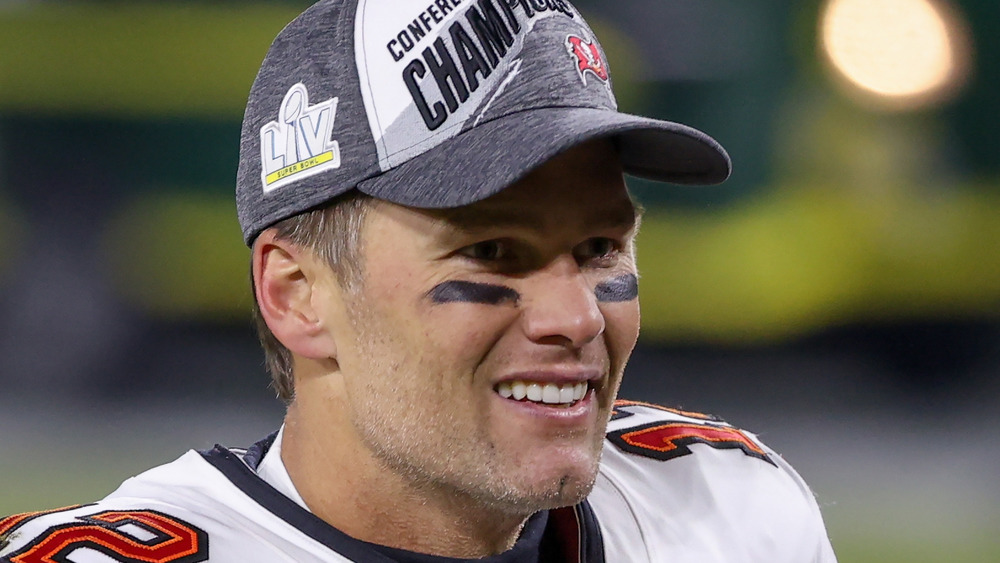 Tom Brady smiling after winning a game