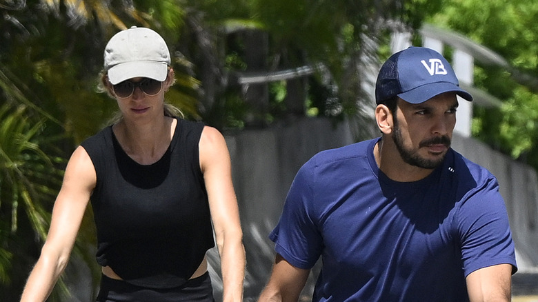 Gisele Bündchen and Joaquim Valente wearing hats while riding bikes