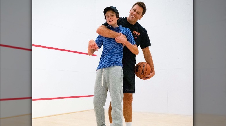 Tom Brady smiling with his son Jack on a basketball court