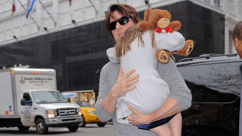 Tom Cruise carrying young Suri Holmes