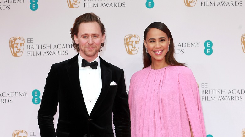 Tom Hiddleston and Zawe Ashton smile at the 2022 BAFTAS