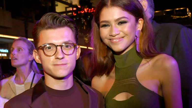 Tom Holland, Zendaya smiling together at an event