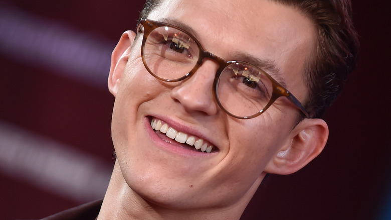 Tom Holland with glasses and wide smile