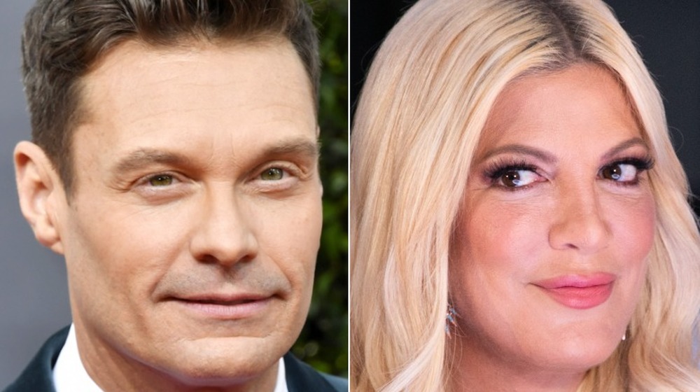 Ryan Seacrest smiling, Tori Spelling staring