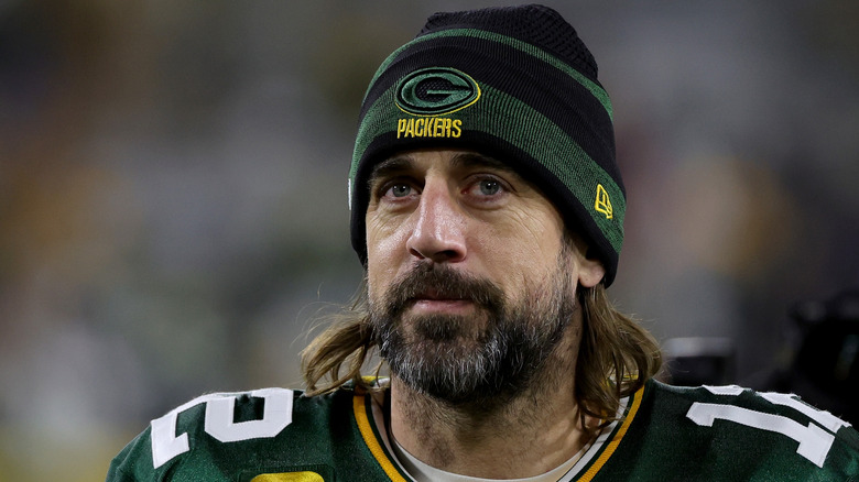 Aaron Rodgers wearing a green Green Bay Packers uniform and a green beanie