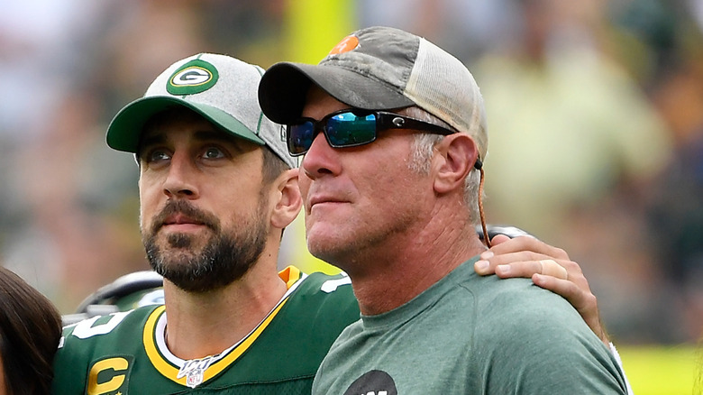 Aaron Rodgers wearing a Green Bay Packers hat with Brett Favre wearing a grey and white hat