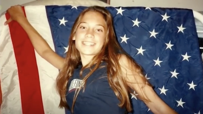 Teenage Ginger Zee smiles with a U.S. flag