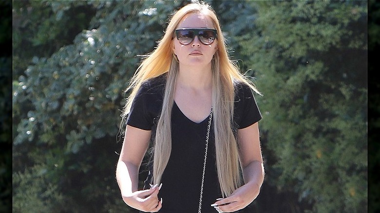 Amanda Bynes with long blonde hair and sunglasses, walking