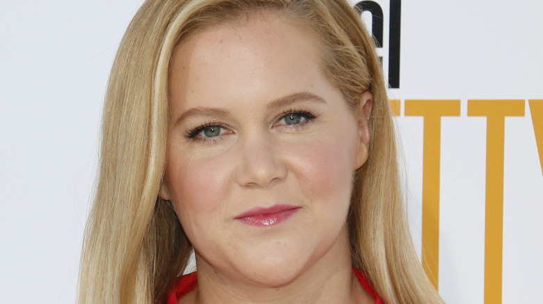 Amy Schumer at an event, looking at camera