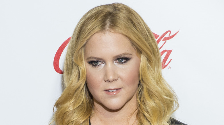 Amy Schumer at an event, looking on