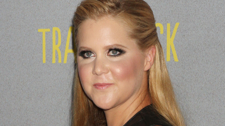 Amy Schumer at an event, looking on