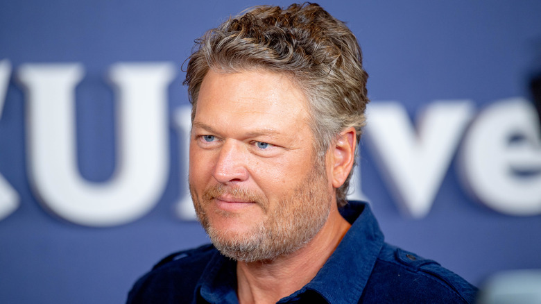 Blake Shelton looks straight ahead in a blue shirt