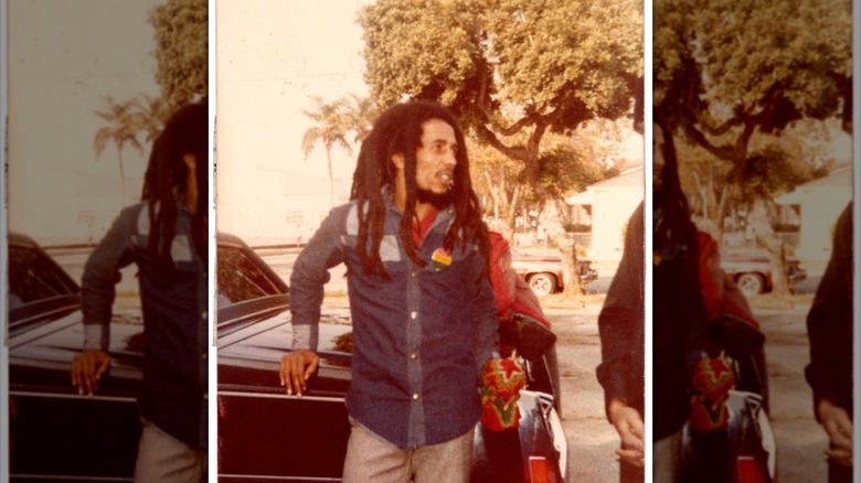 Bob Marley leaning against car